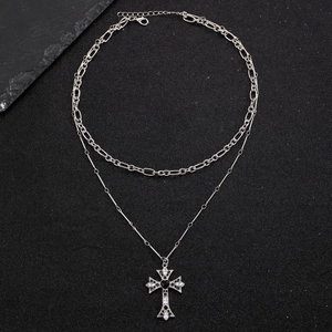 Detail of silver double-layered punk necklace with cross pendant on black stone