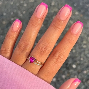 Macro shot of pink heart-shaped gemstone ring stacked with diamond band in rose gold