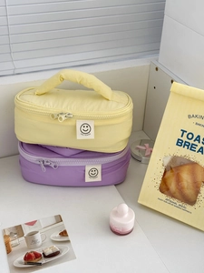 Detail of yellow and purple smileday makeup bags with sturdy handles and zippers