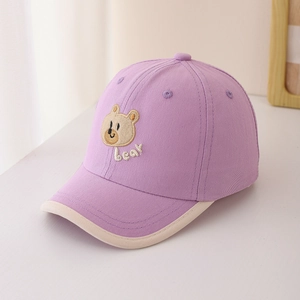 Détail de la casquette bébé en coton violet avec broderie ours et bord de visière crème