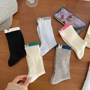 Japanese style colorful ribbed cotton crew socks with cartoon labels on wooden background