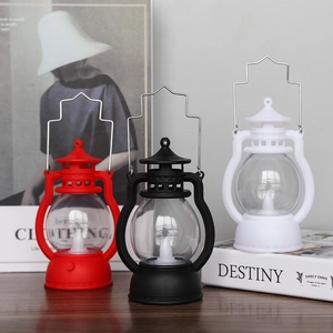 Three vintage-style LED Halloween lanterns in red, black, and white on a wooden table