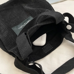 Détail du mini sac seau en velours côtelé noir avec fermeture velcro et rangement interne