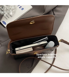 Interior view of brown crocodile texture bag showing phone and lipstick storage