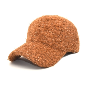 Gros plan détaillé sur la texture en polaire sherpa marron caramel d'une casquette d'hiver