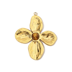 Detailed view of a gold clover pendant featuring a brown cat's eye stone and hammered texture