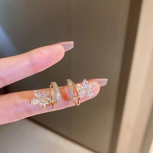 Détail de boucles d'oreilles fleur dorées avec zircons étincelants sur un modèle