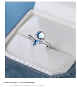 Detailed macro view of S925 silver fishtail ring with blue enamel and moonstone inlay