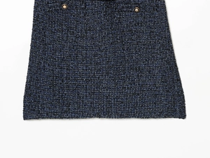 Detail van donkerblauwe tweed stof met decoratieve gouden knopen