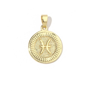 Macro shot of 18k gold plated Pisces zodiac pendant with radial textured edges