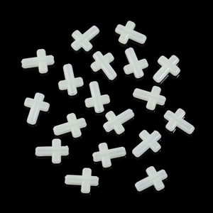 Close-up of white plastic luminous cross beads for DIY jewelry and handmade crafts