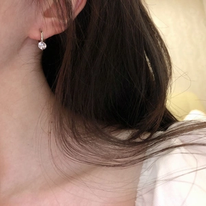 Close-up of a model wearing a S925 sterling silver hoop earring with a round zircon pendant