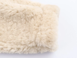Close-up of off-white faux shearling texture on jacket showing soft curly fibers
