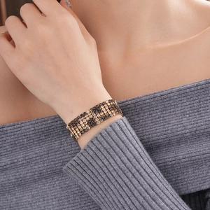 Close-up of multi-row gold bracelet with black and white rhinestones on model wrist