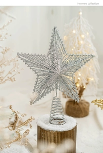 Close-up of silver glitter star tree topper with spiral base on a gold holder