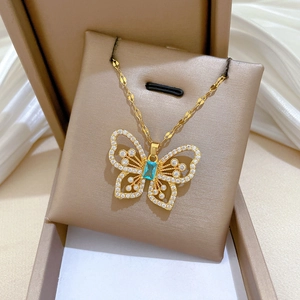 Detailed macro of golden butterfly necklace pendant with blue gemstone and diamonds