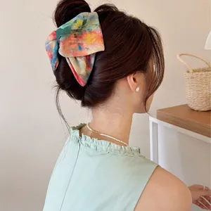 Pince à cheveux nœud artistique avec motif tie-dye coloré pour femme portée par le modèle