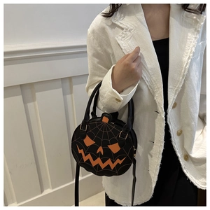 Detail of a black pumpkin-shaped handbag featuring orange facial features and spiderweb stitching