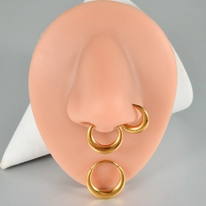 Detailed view of golden titanium thick hoop ring on silicone model for piercing