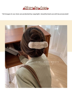 Detailed view of the plush khaki hair claw clip worn on a messy bun hairstyle