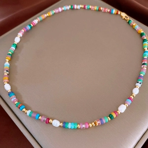 Détail d'un bracelet de perles colorées avec perles baroques et fermoir doré