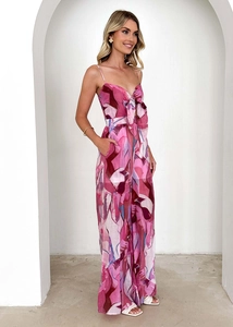 Detail of pink and purple floral jumpsuit featuring a bow tie neckline and wide legs