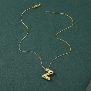 Chic gold-plated puff letter Z pendant necklace on dark green textured background