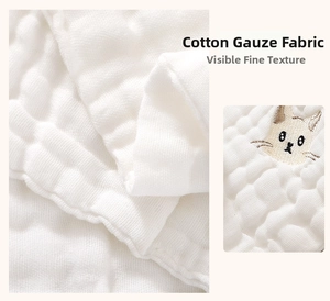 Macro detail of breathable white cotton gauze fabric with cute cat head embroidery