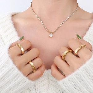Elegant gold plated tennis necklace with zircons and spiral textured wide rings on model