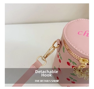 Detail of pink cherry bucket bag featuring gold floral dual zippers and detachable hook