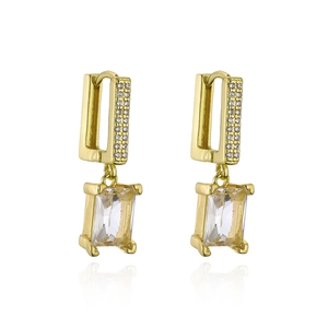 Dettaglio di orecchini geometrici placcati oro con zirconi rettangolari e riflessi lucidi
