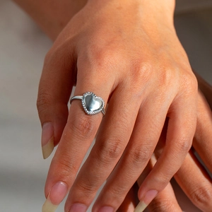 Sleek silver stainless steel heart ring with beaded edge detail worn on hand
