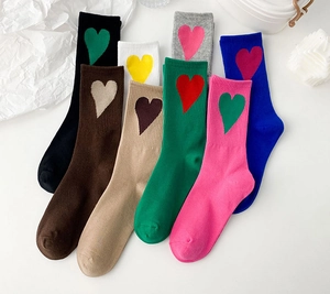 Flat lay of colorful mid-calf heart socks in pastel shades with soft ribbed cuffs