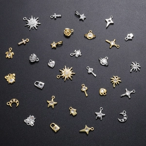Mixed micro-pave zircon charms in gold and silver finish with star, moon, and cross shapes