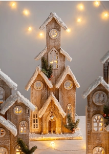 Detail of wooden Christmas church with LED lights, snow texture and pine branch accents