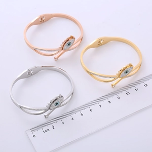 Polished evil eye cross spring bangles in rose gold, gold, and silver finishes