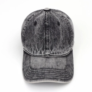 Macro shot of washed gray denim texture and stitching detail on the classic baseball cap
