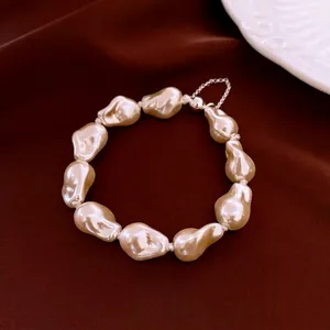 Baroque irregular pearl bracelet with silver extension chain on elegant red velvet background
