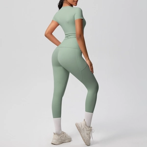 Detail of sage green compression yoga set with high-waist leggings and short sleeve top