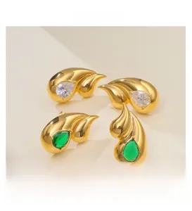 Detail view of double teardrop gold-plated stud earrings with clear and green stones