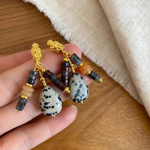 Macro detail of bohemian natural jasper stone drop earrings with gold metallic accents