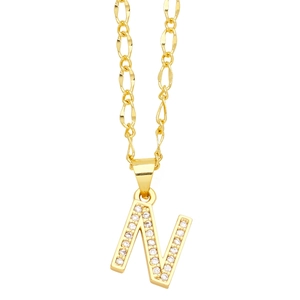 Macro detail of gold letter N pendant with pavé cubic zirconia on Figaro chain necklace
