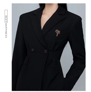 Macro view of Christmas candy cane brooch with red bow on a black suit lapel