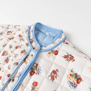 Close-up of a floral quilted jacket with blue contrast trim and white button details