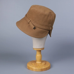 Brown vintage cotton bucket hat with decorative band and metal buckle on mannequin