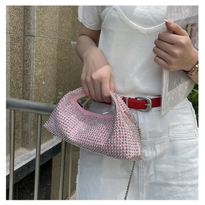 Close-up of pink rhinestone handbag with silver metal studs and detachable chain strap