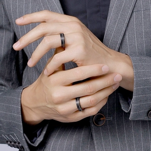 Men's matte black tungsten ring with silver line detail on grey business suit background