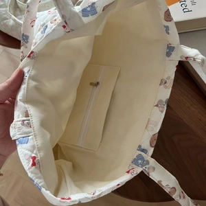 Close-up of the interior zipper pocket and floral quilted lining of the tote bag