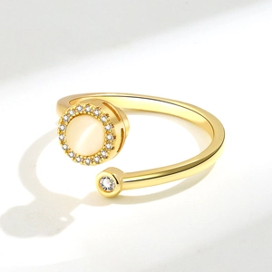 Detail of golden spinner ring featuring round cat eye stone and pavé zircon accents