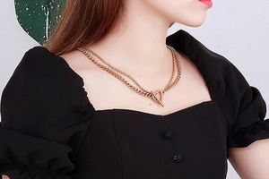 Close-up of double layer gold stainless steel chain necklace with heart toggle on a model